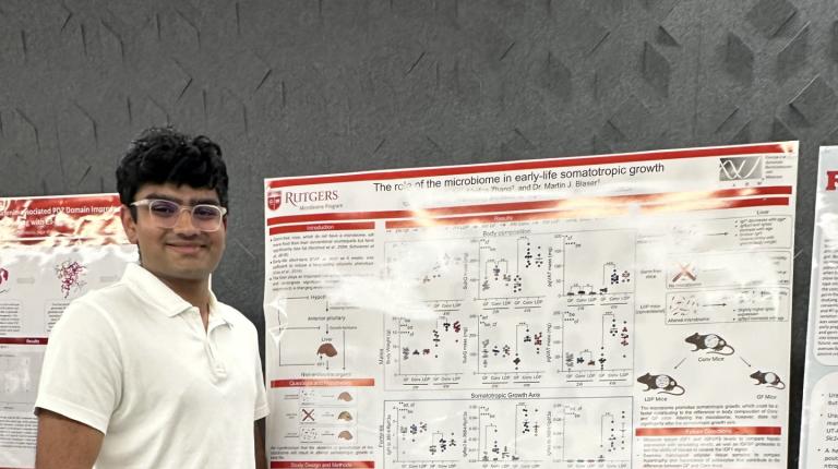 Prit standing next to his poster