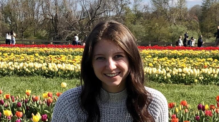 Profile photo of Alexandra Grumet standing in front of field of flowers