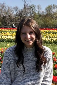 Profile photo of Alexandra Grumet standing in front of field of flowers