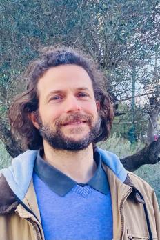 photo of Arnon standing in front of a tree