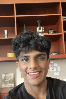 photo of Atharv in front of bookshelf