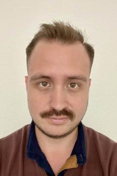 headshot of Ernesto in front of beige background