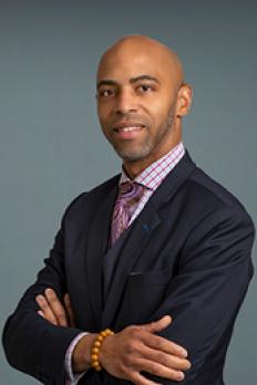 headshot of Fritz standing in front of grey background