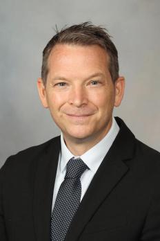 headshot of James in front of grey background