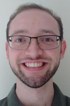 headshot of Jesse in front of grey background