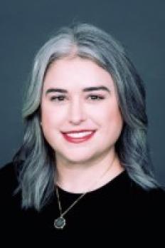 headshot of Mary Ann in front of dark grey background