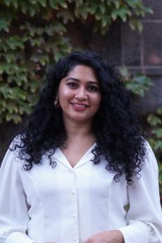 photo of Rachana standing in front of bush