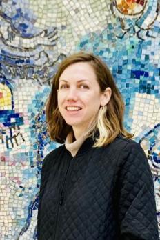 Timna standing in front of art wall