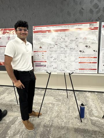 Prit standing next to his poster
