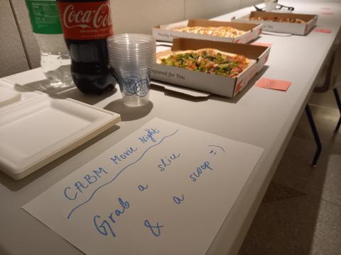 table with pizza and soda and signage
