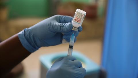 Vile of moderna vaccine being drawn into syringe