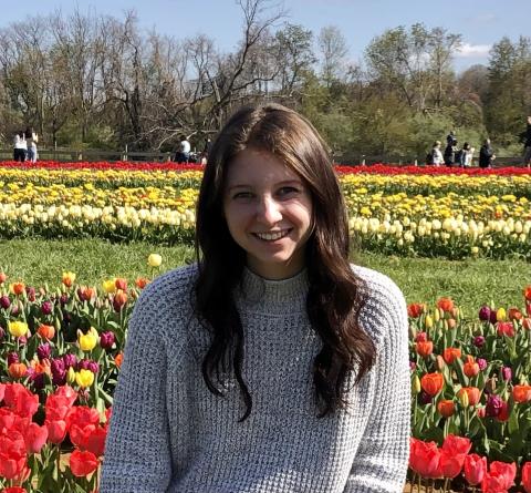 Profile photo of Alexandra Grumet standing in front of field of flowers