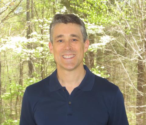 Profile of Matt Redinbo standing in front of woods
