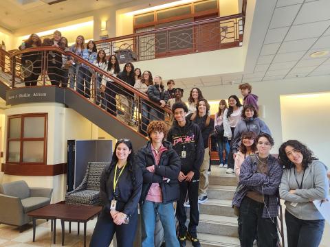 HS students standing on atrium staircase 