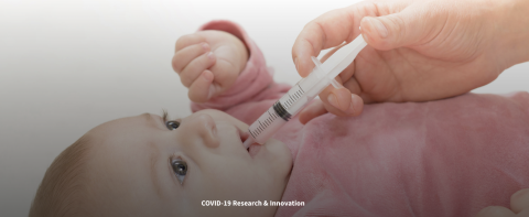 infant being fed with a syringe