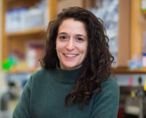 Tami in green sweater standing in laboratory