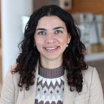 photo of Ana Maldonado standing in front of book case